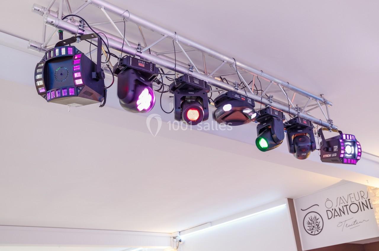 Projecteurs colorés suspendus à une structure métallique dans un espace intérieur lumineux.