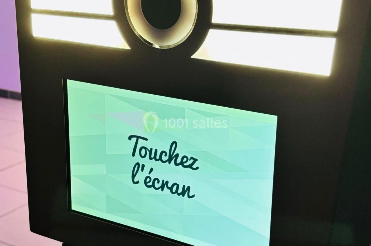 Borne interactive avec écran tactile affichant le message ’Touchez l'écran’, éclairée par des lumières LED.