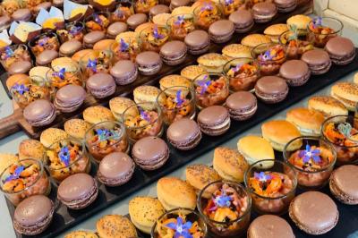 Dés de saumon, ananas et canneberges garnis d'aneth, présentés dans une assiette noire.