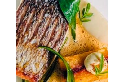 Dés de saumon, ananas et canneberges garnis d'aneth, présentés dans une assiette noire.