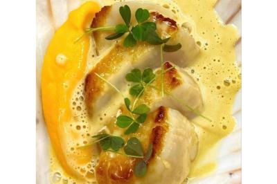 Dés de saumon, ananas et canneberges garnis d'aneth, présentés dans une assiette noire.