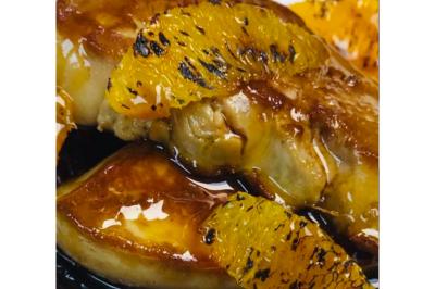 Dés de saumon, ananas et canneberges garnis d'aneth, présentés dans une assiette noire.