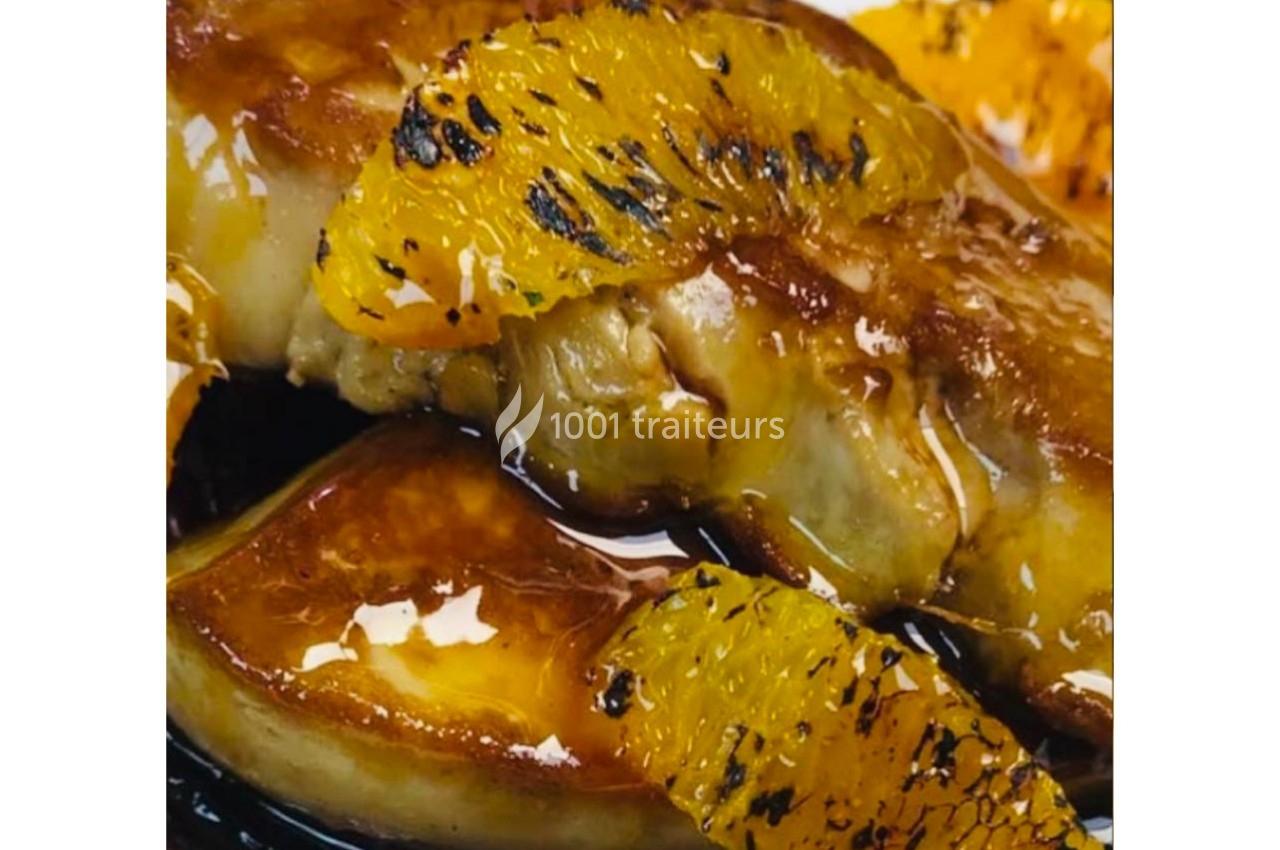 Foie gras poêlé nappé de sauce, accompagné de tranches d'orange caramélisées.