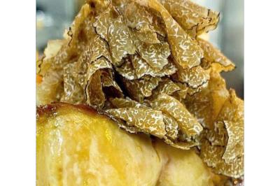 Dés de saumon, ananas et canneberges garnis d'aneth, présentés dans une assiette noire.