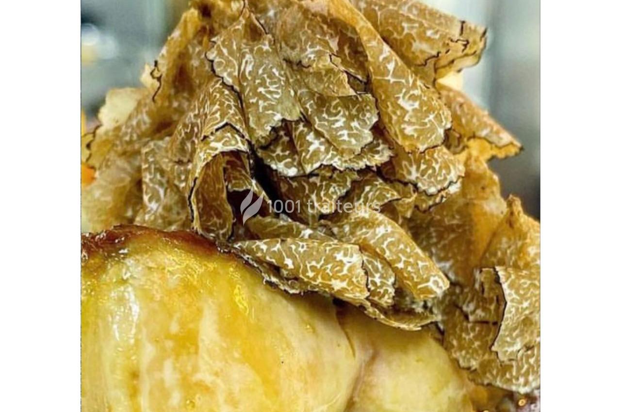 Truffes fraîches finement râpées sur un plat doré, mettant en valeur leur texture et leur couleur marbrée.