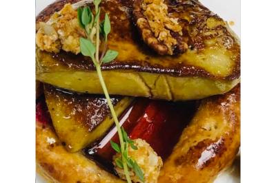 Dés de saumon, ananas et canneberges garnis d'aneth, présentés dans une assiette noire.