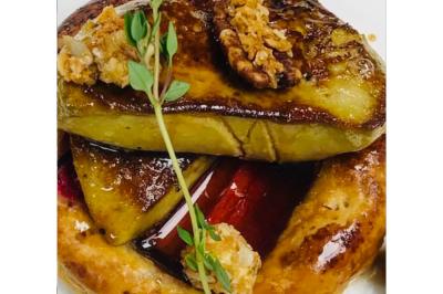 Dés de saumon, ananas et canneberges garnis d'aneth, présentés dans une assiette noire.