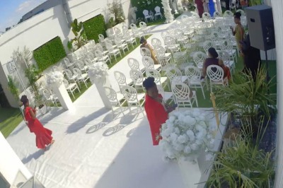 Salle de réception avec table dressée, chaises en bois sculpté, nappes vertes et décorations florales élégantes.