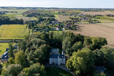 Salle de réception avec tables dressées, chaises noires, murs sombres et un buffet en arrière-plan.