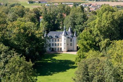Salle de réception avec tables dressées, chaises noires, murs sombres et un buffet en arrière-plan.