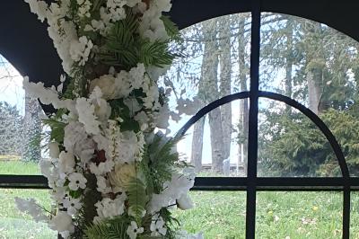 Salle de réception avec tables dressées, chaises noires, murs sombres et un buffet en arrière-plan.