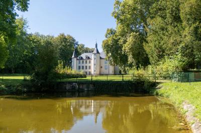 Salle de réception avec tables dressées, chaises noires, murs sombres et un buffet en arrière-plan.