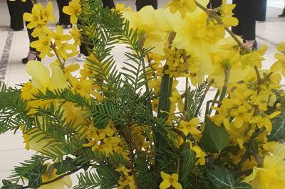 Salle de réception avec tables dressées, chaises noires, murs sombres et un buffet en arrière-plan.
