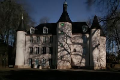 Salle de réception avec tables dressées, chaises noires, murs sombres et un buffet en arrière-plan.