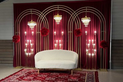 Salle décorée pour un 50e anniversaire, avec tables alignées, nappes rouges et ballons suspendus.