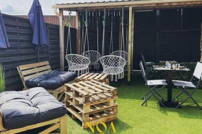 Salle de réception décorée avec des tables dressées et un buffet de cocktails sur une nappe blanche.