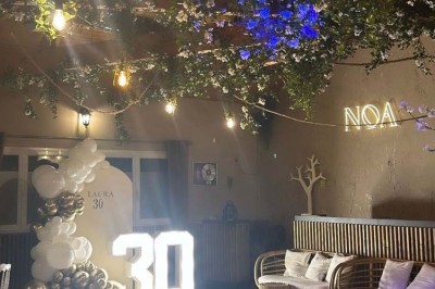 Salle de réception décorée avec des tables dressées et un buffet de cocktails sur une nappe blanche.