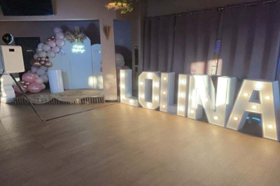 Salle de réception décorée avec des tables dressées et un buffet de cocktails sur une nappe blanche.