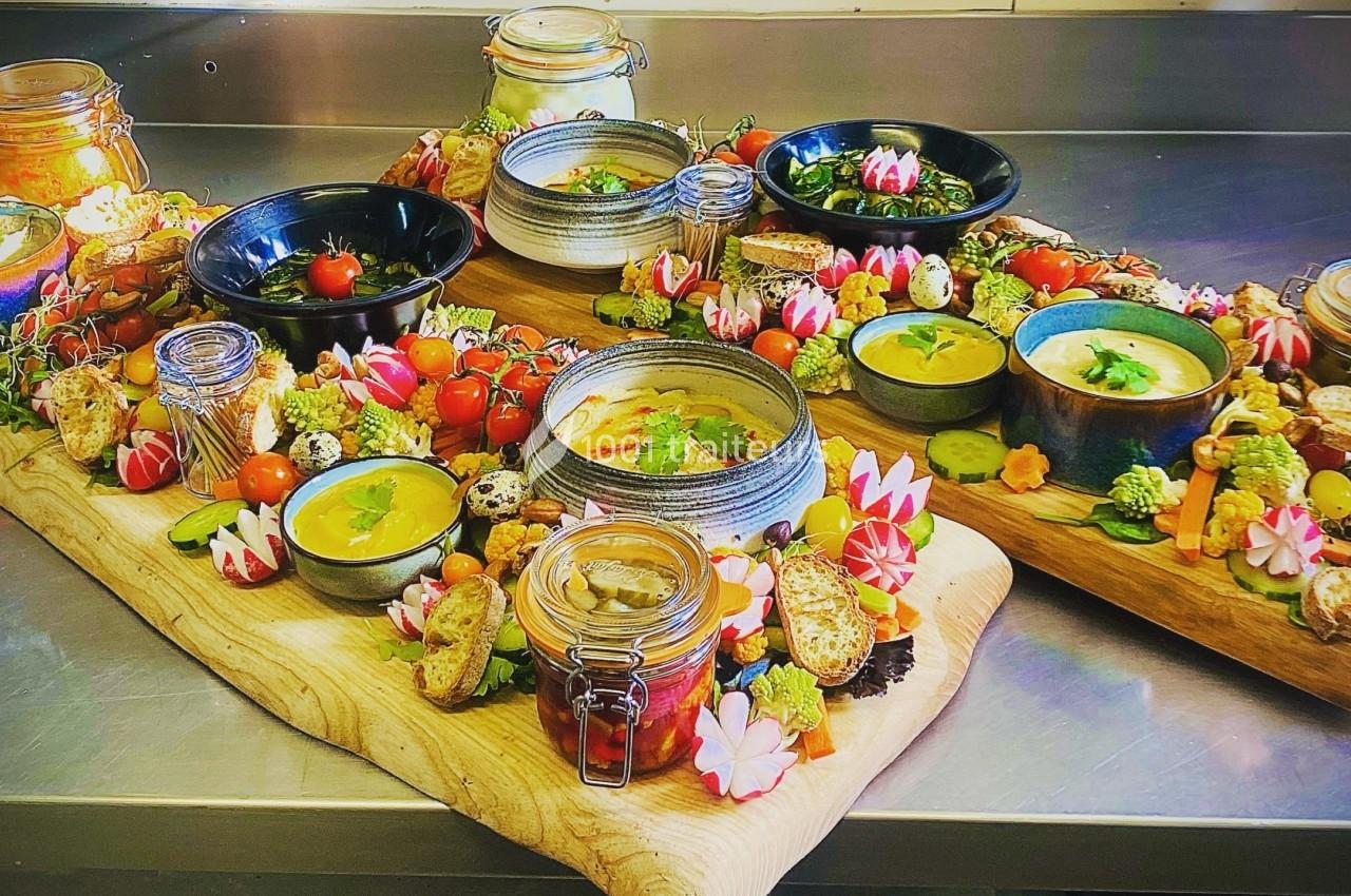 Plateaux en bois garnis de soupes, légumes frais, tartines, sauces et décorations colorées dans une cuisine.