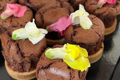 Plateau de charcuterie avec jambon, saucisson, cornichons, tomates cerises et feuilles de salade en décoration.