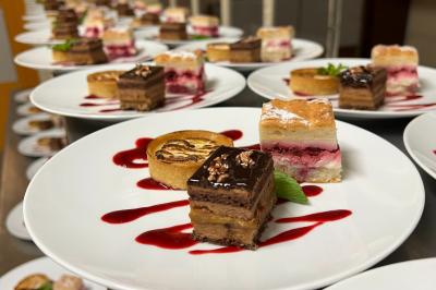 Plateau de charcuterie avec jambon, saucisson, cornichons, tomates cerises et feuilles de salade en décoration.
