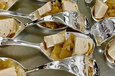 Plateau de charcuterie avec jambon, saucisson, cornichons, tomates cerises et feuilles de salade en décoration.