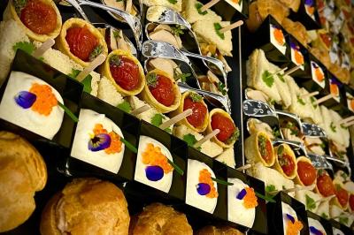 Plateau de charcuterie avec jambon, saucisson, cornichons, tomates cerises et feuilles de salade en décoration.