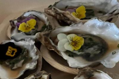 Plateau de charcuterie avec jambon, saucisson, cornichons, tomates cerises et feuilles de salade en décoration.