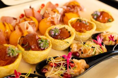 Plateau de charcuterie avec jambon, saucisson, cornichons, tomates cerises et feuilles de salade en décoration.