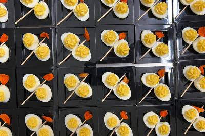 Plateau de charcuterie avec jambon, saucisson, cornichons, tomates cerises et feuilles de salade en décoration.