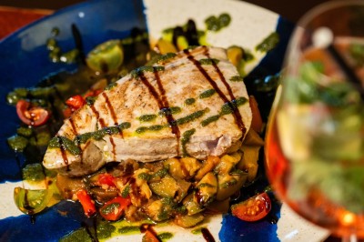 Dessert composé d'un biscuit chaud garni de glace à la vanille, décoré de chocolat et caramel, avec un verre de vin…