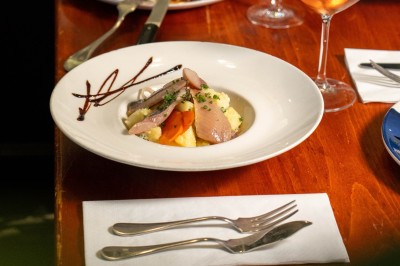 Dessert composé d'un biscuit chaud garni de glace à la vanille, décoré de chocolat et caramel, avec un verre de vin…