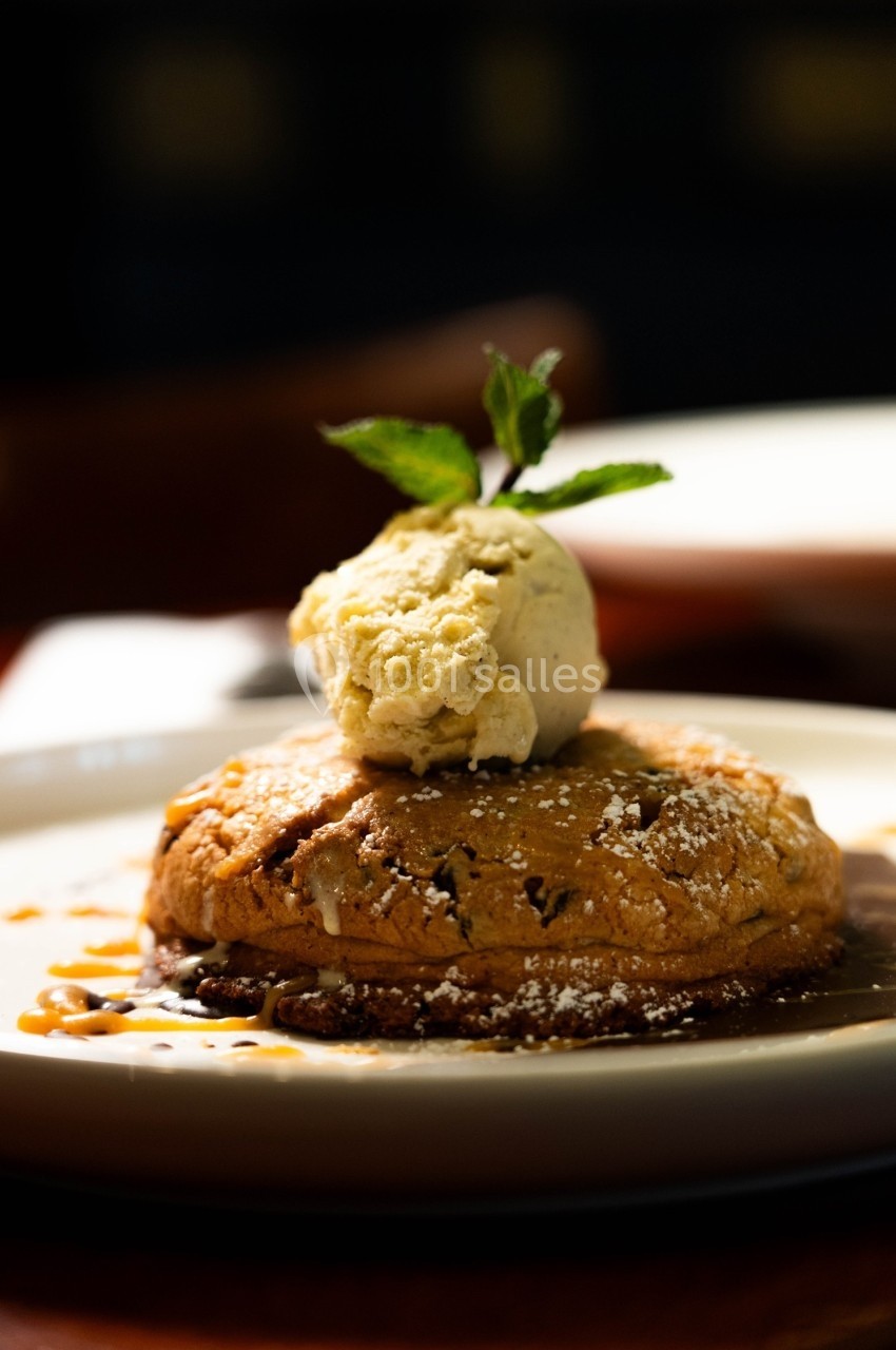 Dessert composé d'une tarte chaude garnie de glace à la vanille et décorée d'une feuille de menthe.