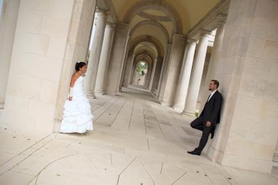 Un couple de mariés échange un regard complice devant l'autel d'une église ornée de bois sculpté.