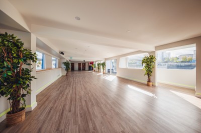 Bateau naviguant sur une rivière avec un groupe de personnes rassemblées sur le pont supérieur.