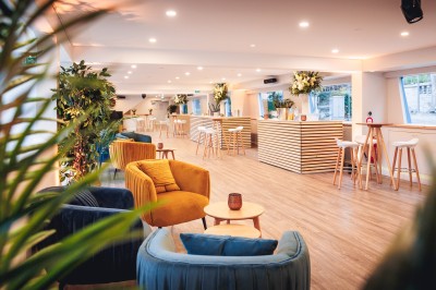 Bateau naviguant sur une rivière avec un groupe de personnes rassemblées sur le pont supérieur.