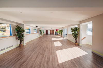 Bateau naviguant sur une rivière avec un groupe de personnes rassemblées sur le pont supérieur.