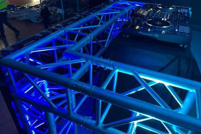 Écran géant installé en extérieur diffusant un match de football, avec une plage visible en arrière-plan.