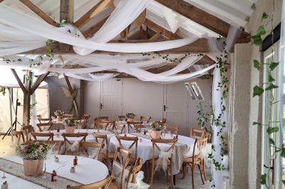 Chambre lumineuse avec lit double, fauteuil en bois, baignoire blanche et grande fenêtre donnant sur l'extérieur.