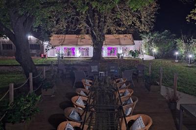 Chambre lumineuse avec lit double, fauteuil en bois, baignoire blanche et grande fenêtre donnant sur l'extérieur.