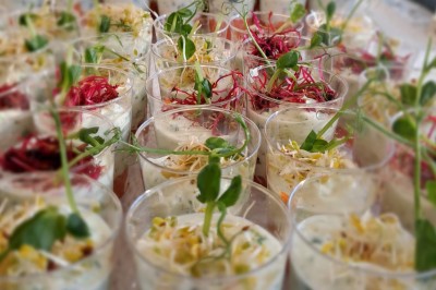 Miniature Traiteur Lattes (Hérault) - A la Bonne Franquette #17 Borne photo interactive éclairée entourée de poteaux dorés et cordons rouges sur un tapis rouge dans une salle lumineuse.