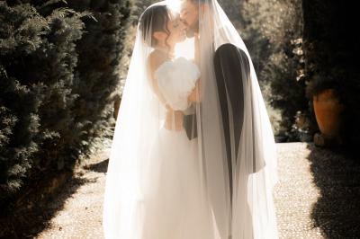 Salle lumineuse avec poutres apparentes, tables blanches disposées en U et chaises rouges, éclairée par des lustres et des…