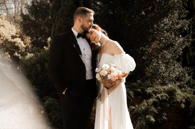 Salle lumineuse avec poutres apparentes, tables blanches disposées en U et chaises rouges, éclairée par des lustres et des…