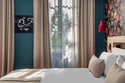 Salle lumineuse avec poutres apparentes, tables blanches disposées en U et chaises rouges, éclairée par des lustres et des…