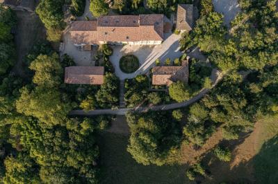 Salle lumineuse avec poutres apparentes, tables blanches disposées en U et chaises rouges, éclairée par des lustres et des…