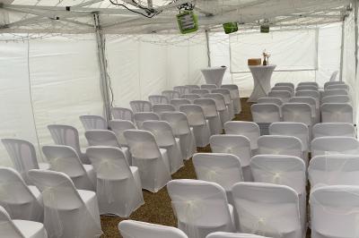 Façade d'un bâtiment ancien avec porte vitrée ouverte sur une salle aménagée, table dressée à l'extérieur.