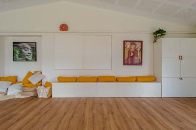 Jardin verdoyant avec fleurs sauvages, arbres et arbustes, entouré d'une clôture en bois sous un ciel dégagé.