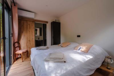 Jardin verdoyant avec fleurs sauvages, arbres et arbustes, entouré d'une clôture en bois sous un ciel dégagé.