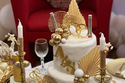 Jardin verdoyant avec fleurs sauvages, arbres et arbustes, entouré d'une clôture en bois sous un ciel dégagé.