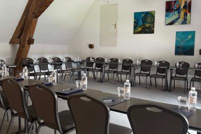 Comptoir en bois avec étagères contenant des bouteilles, tasses, objets décoratifs et plantes dans un espace lumineux.